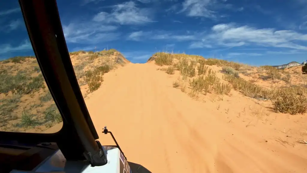 Cresting over a sand dune in the Polaris RZR