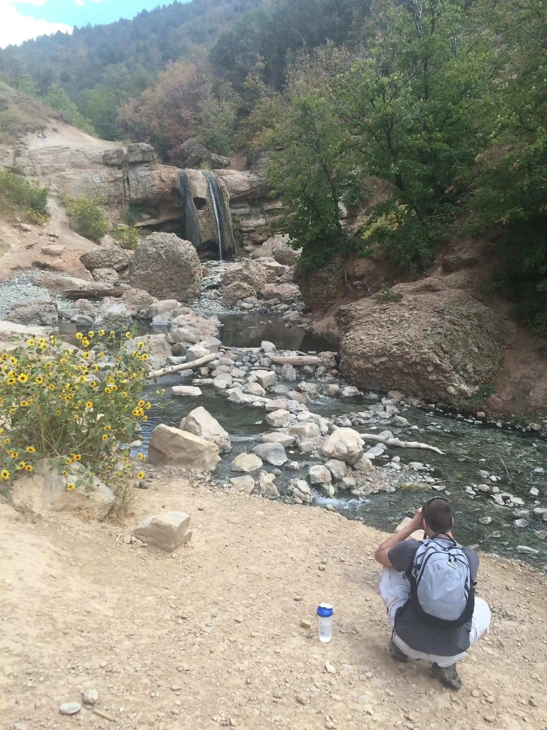 Keith taking a photo of a waterfall while out on a hike