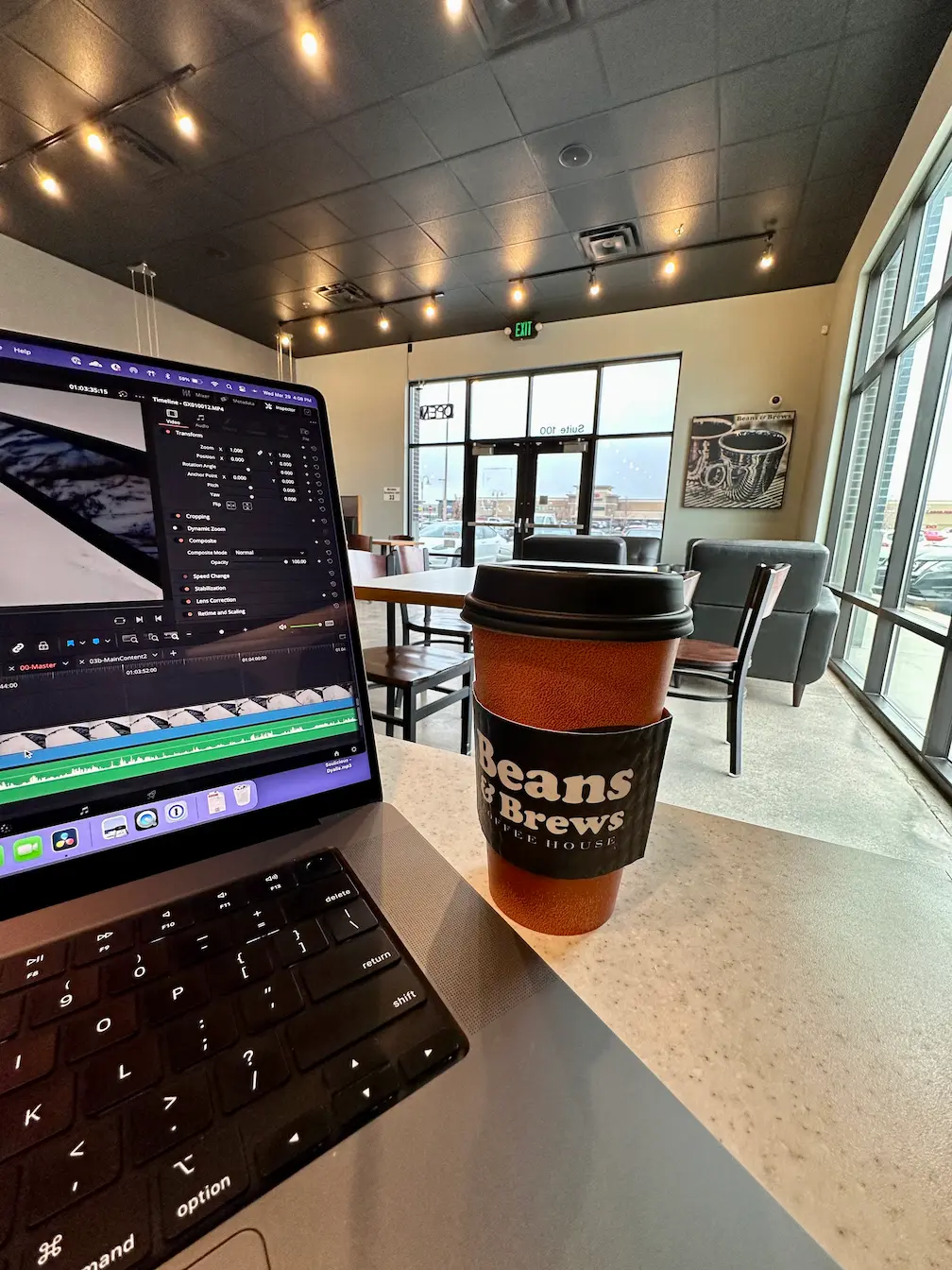 Lindsey is editing a ski video at a local Beans and Brews coffee shop.