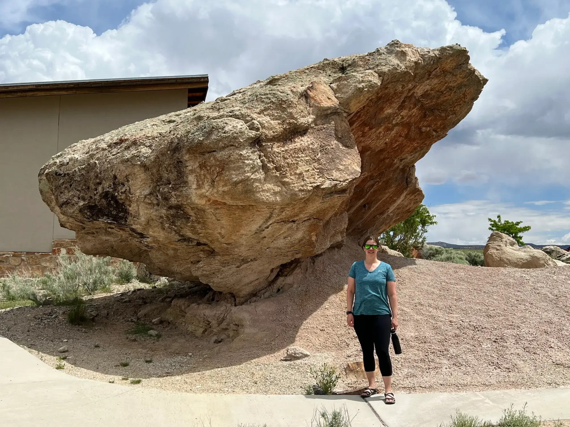 Lindsey is standing below a massive boulder near the picnic area at Jurassic National Monument