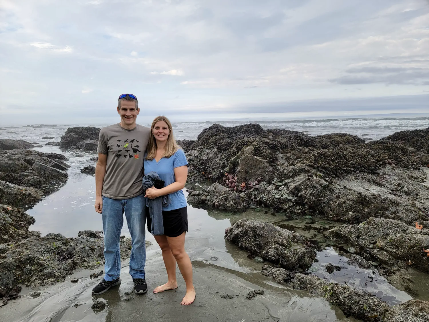 Keith and Lindsey are standing in front of a tide pool at Endert's Beach