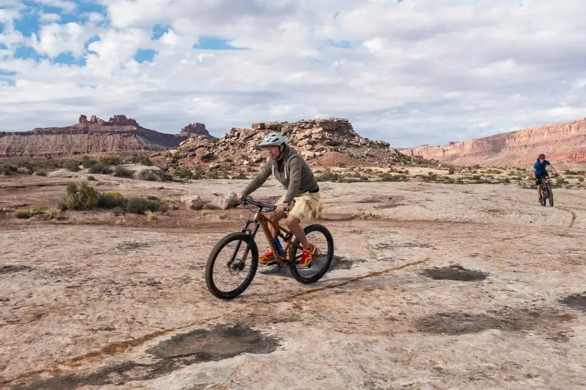 Yi riding his mountain bike across a slickrock slab