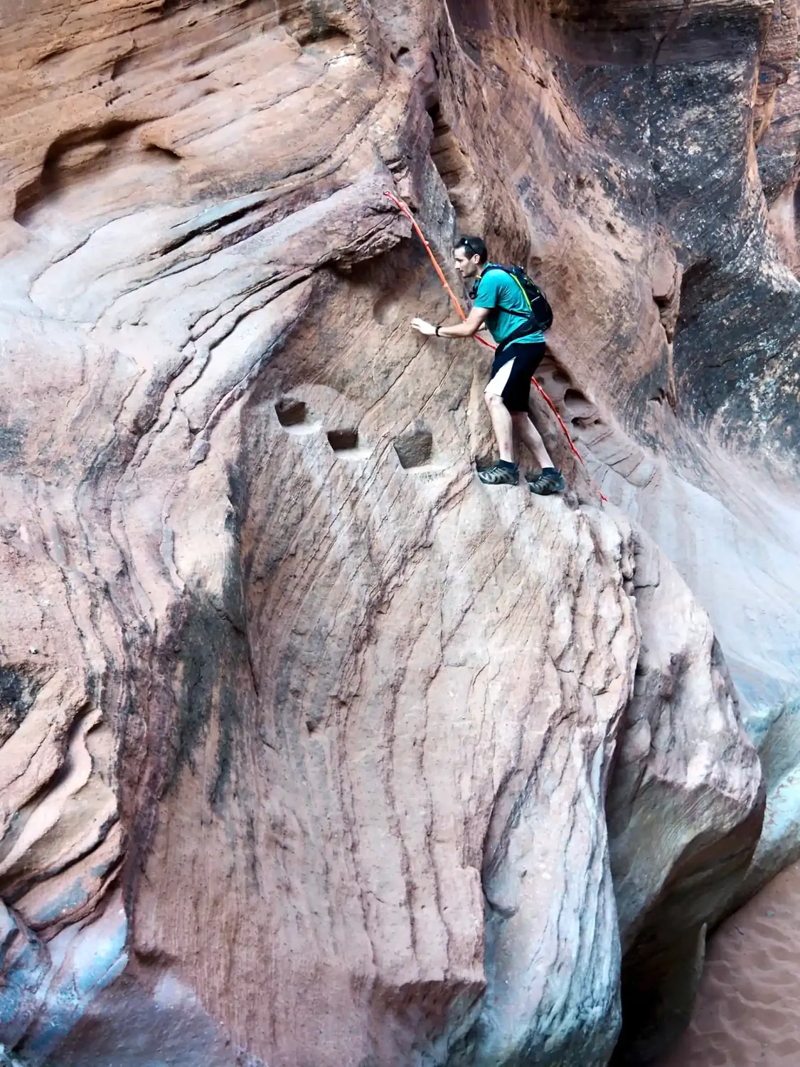 Keith is traversing the Moki steps while using the rope for assistance