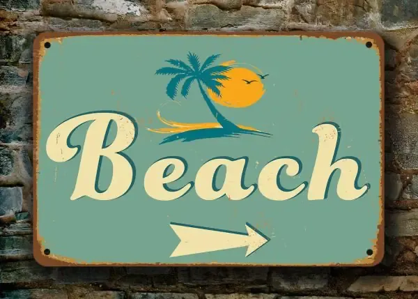 A rusted metal sign stating "Beach" with an arrow pointing (source: Classic Metal Signs)