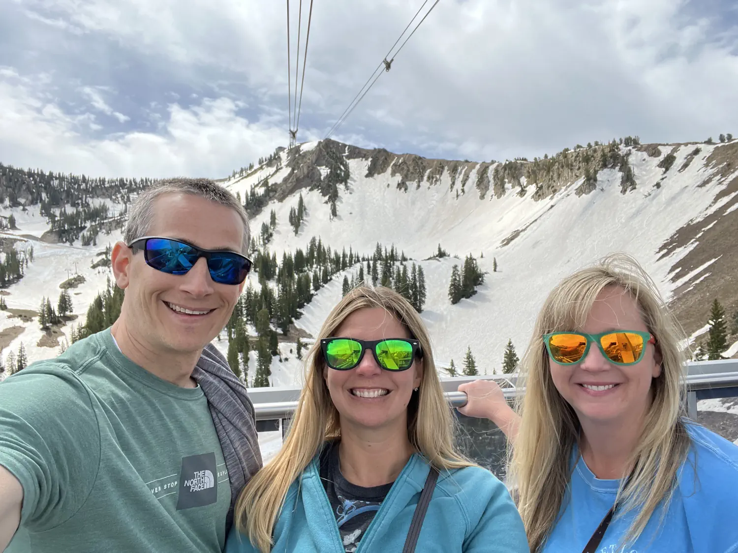 Keith, Lindsey, and Tiffany are on the rooftop balcony of the Snowbird Tram nearing the top of Hidden Peak