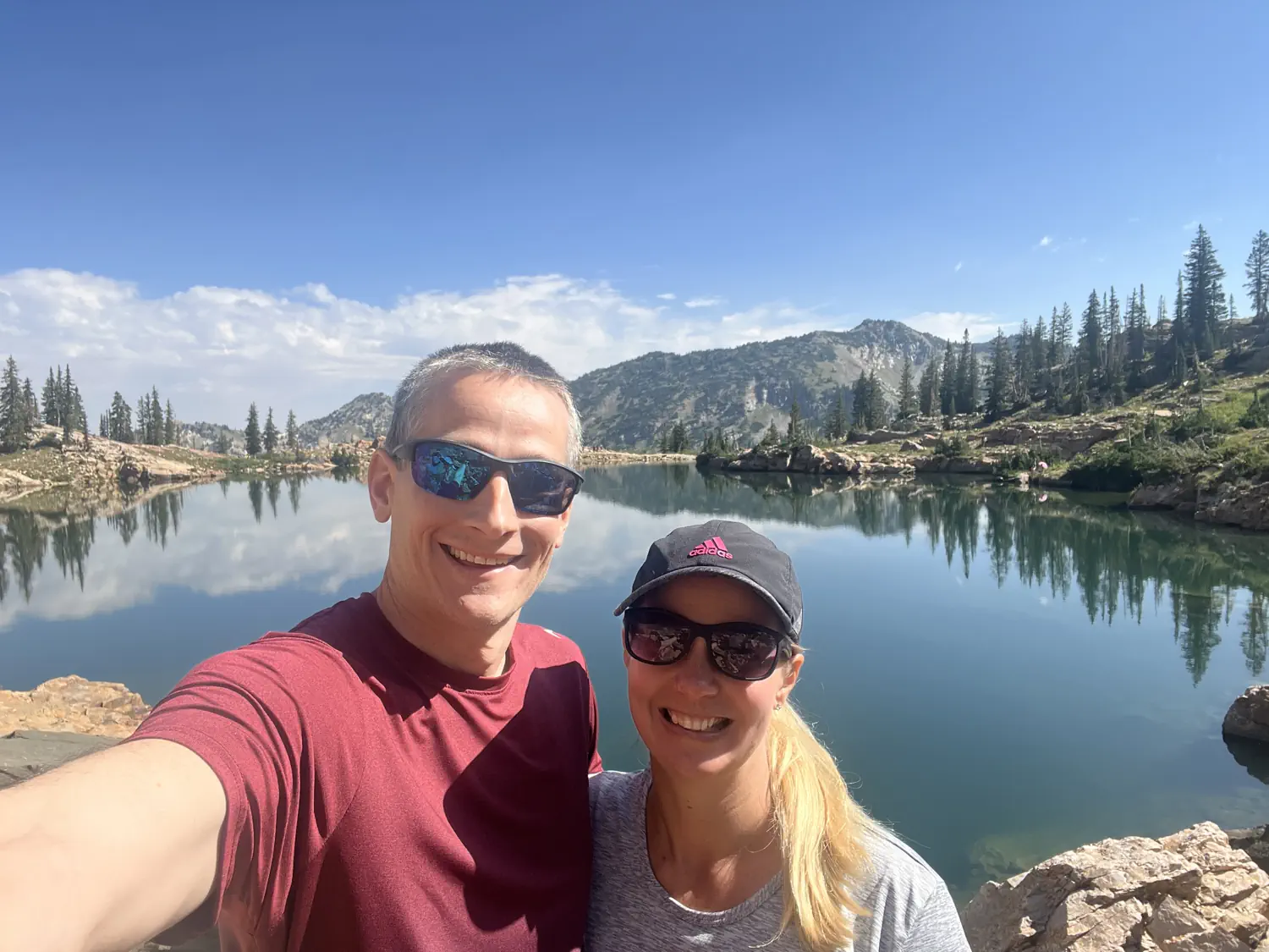 Keith and Lindsey are taking a selfie in front of Cecret Lake at Alta Ski Area