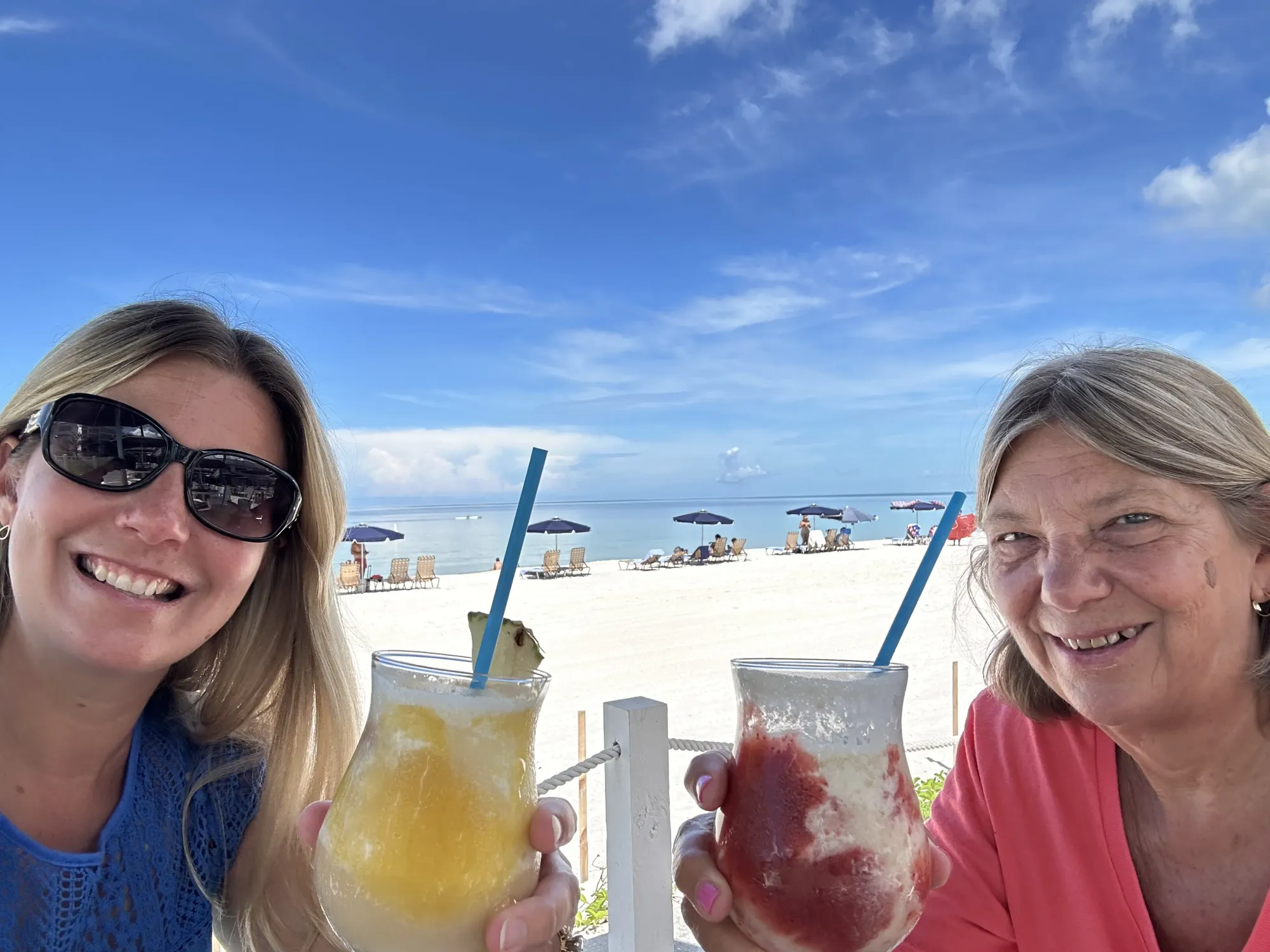 Lindsey and her mom are enjoying tropical drinks at a beachside restaurant in Florida